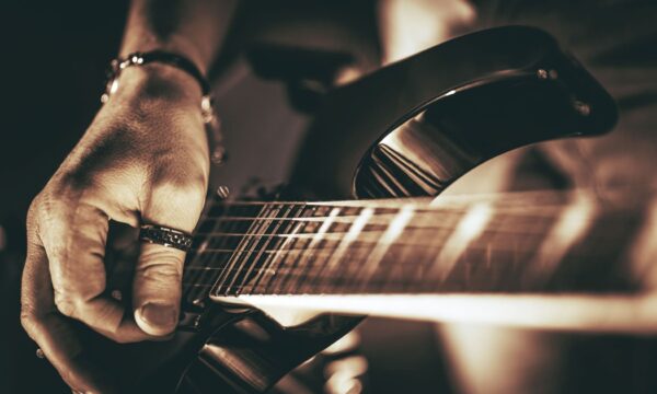 Guitarist Plays. Electric Guitar Playing Closeup Photo. Rockman Guitar Player Music Theme.